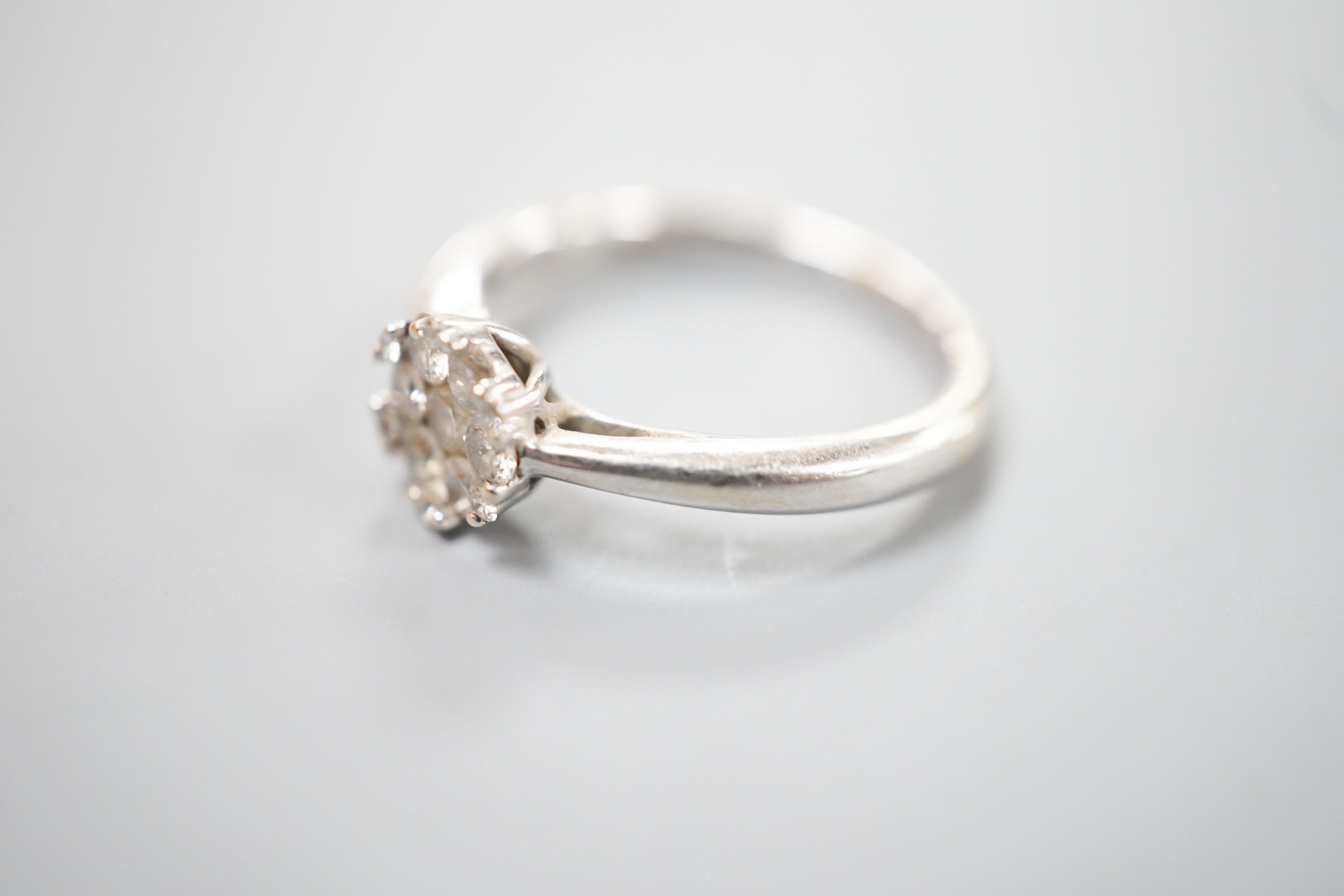 A modern 18ct white gold and diamond set hexagonal cluster ring, size H, gross 2.8 grams.